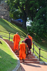 Four monks are walking on the stairs