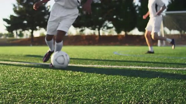 A soccer player does some fancy footwork while dribbling down the field 
