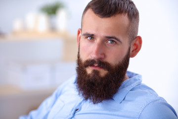 Fototapeta premium Young businessman sitting on chair in office