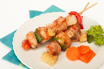 Fried barbeque meat on a bamboo sticks with vegetables
