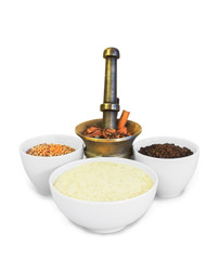 Frontal still life of white ceramic and brass vessels with cereals and spices