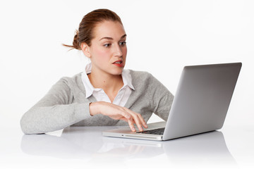 worried 20s female student writing on laptop in white office