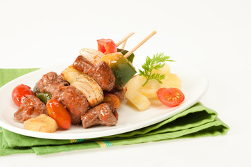 Fried barbeque meat on a bamboo sticks with vegetables