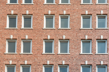 Red brick wall with rows of windows