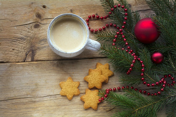 Cup of coffee with cookies in star shape and fir branches with c