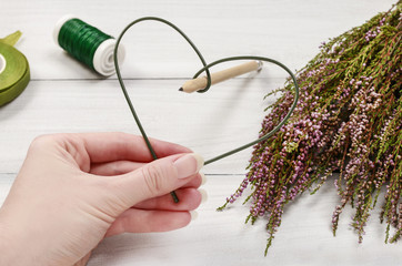 Florist at work: steps of making heather (erica) door wreath in