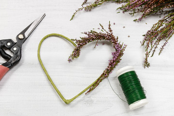 Florist at work: steps of making heather (erica) door wreath in