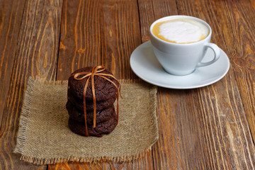 Stack of homemade chocolate chip cookies and cappuccino