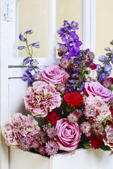 Floral arrangement with pink roses, carnations and delphinium fl