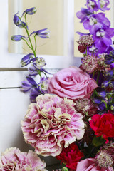 Floral arrangement with pink roses, carnations and delphinium fl