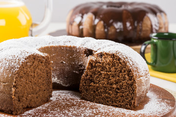 Chocolate cake on the table with carrot cake in the background.