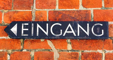 Fototapeta premium Eingang - altes Schild auf Hauswand mit Ziegelsteinen