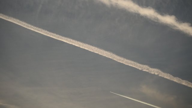 Airplane condensation trails on the sky at sunset