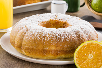 Orange cake on the table with fruits and juice.