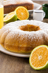 Orange cake on the table with fruits and juice.