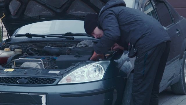The man repairs a xenon headlight and checks