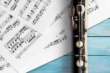 Old flute with sheet music on blue wooden boards