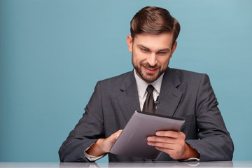 Handsome newscaster working at studio with laptop