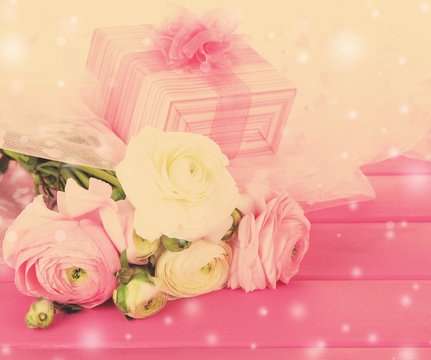 Ranunculus (persian buttercups) and gift box on wooden background