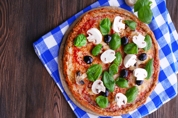 Tasty pizza with vegetables and basil on table close up