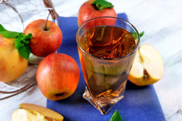 Glass of apple juice with fruits and fresh mint on table close up