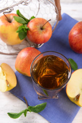 Glass of apple juice with fruits and fresh mint on table close up