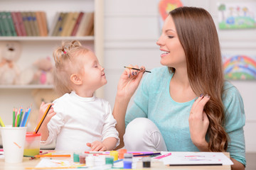 Cheerful friendly family is drawing with joy