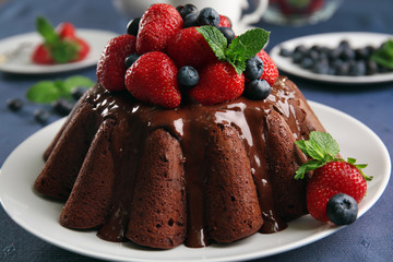 Delicious chocolate cake with strawberries in plate on table, closeup