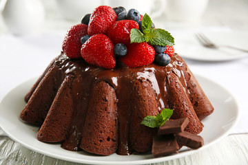 Delicious chocolate cake with strawberries in plate on table, closeup