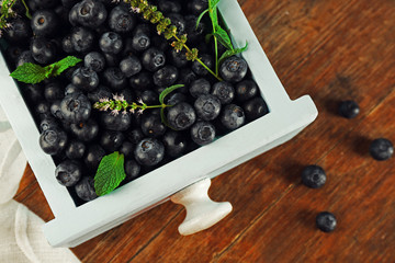 Fresh blueberries in crate on table close up