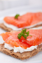 Sandwich with smoked salmon and cottage cheese on a white plate..