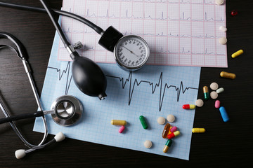 Blood pressure meter and stethoscope, on dark wooden background