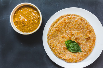 Roti and chicken curry. Top view on black background