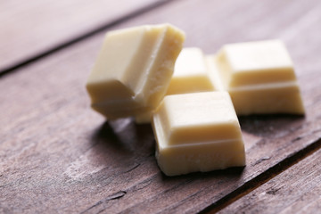 White chocolate pieces on wooden background