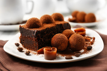 Slice of chocolate cake with a truffle on plate closeup