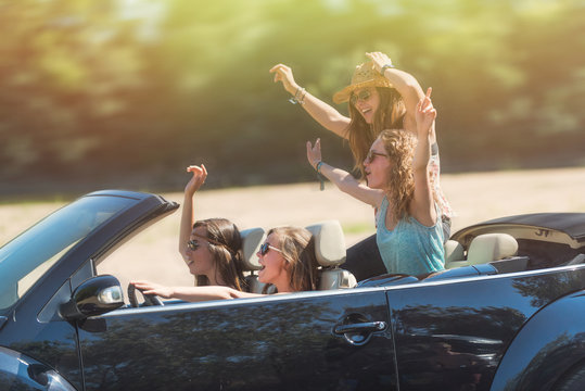 Girl's weekend ! young women are having fun in a black convertible