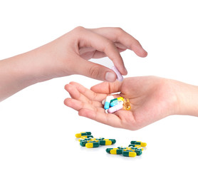 Drug capsules and pills in hand with drinking water