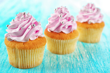 Tasty cupcakes on color wooden background