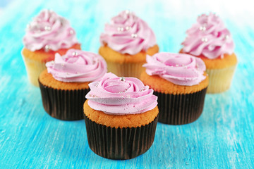 Tasty cupcakes on color wooden background