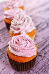 Tasty cupcakes on color wooden background