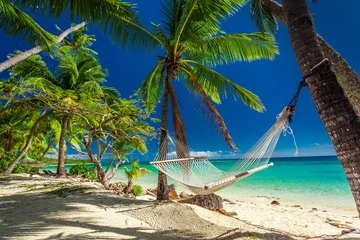 Washable wall murals Tropical beach Empty hammock in the shade of palm trees on tropical Fiji
