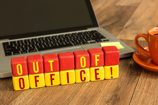 Out Of Office Written On A Wooden Cube In A Office Desk