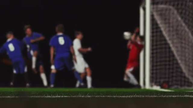 Close up of a corner kick and a goal during a soccer game at night
