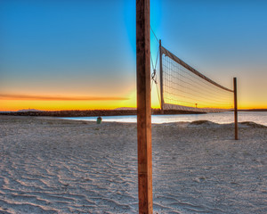 Beach volleyball courts sit empty at sunset.
