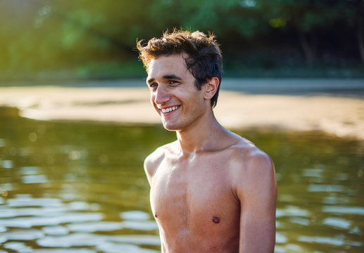 Portrait of a young man having fun with his friend at the lake 