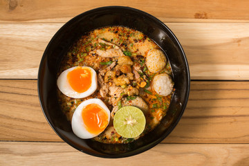 bowl of noodles with vegetables and soft boiled egg on wooden ta