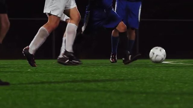 The camera pans with a soccer team as they dribble down the field
