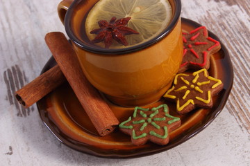 Cup of tea, fresh gingerbread and cinnamon on old wooden background, christmas time