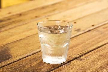 glass of clear alcohol on wooden table