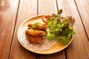 chicken wings with vegetables on wooden table